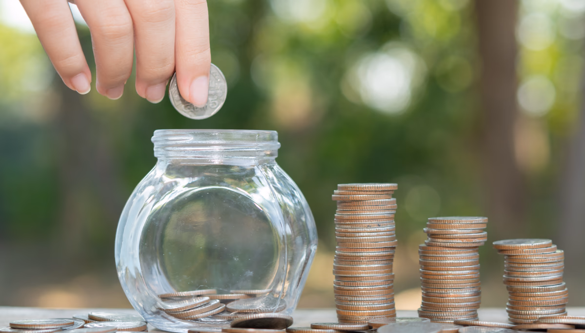 A person adding money into a box, symbolizing the process of saving for an emergency fund.